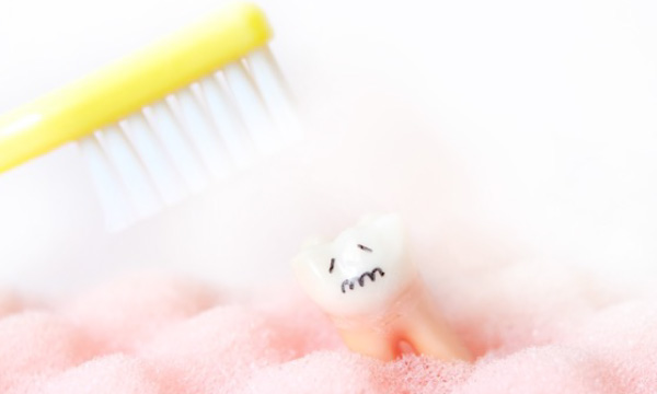 歯ブラシが当たり悲しそうな顔をする歯