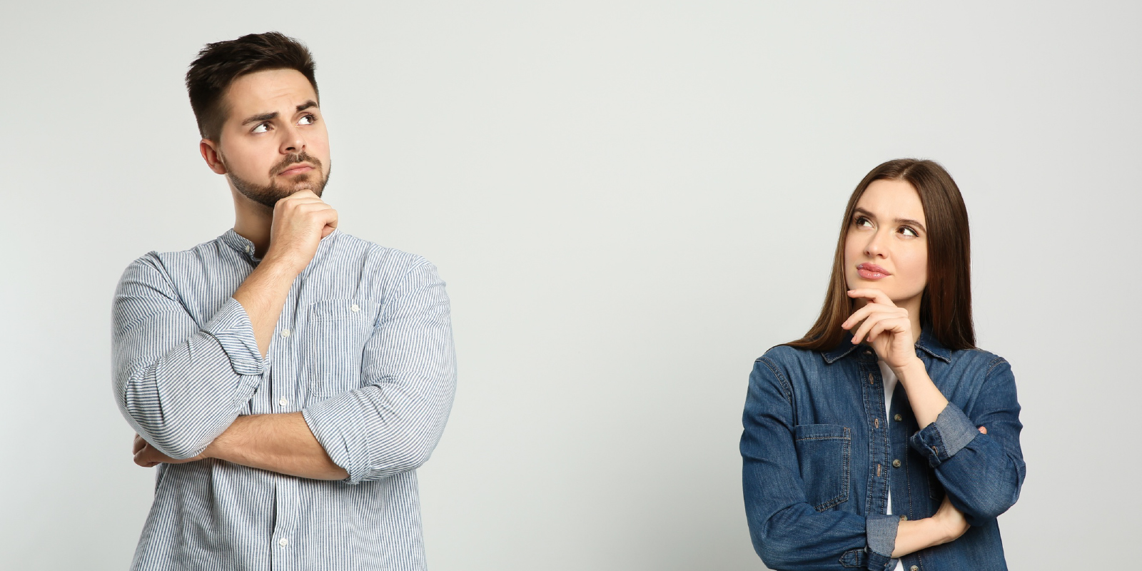 顎に手を置き考える男女の写真