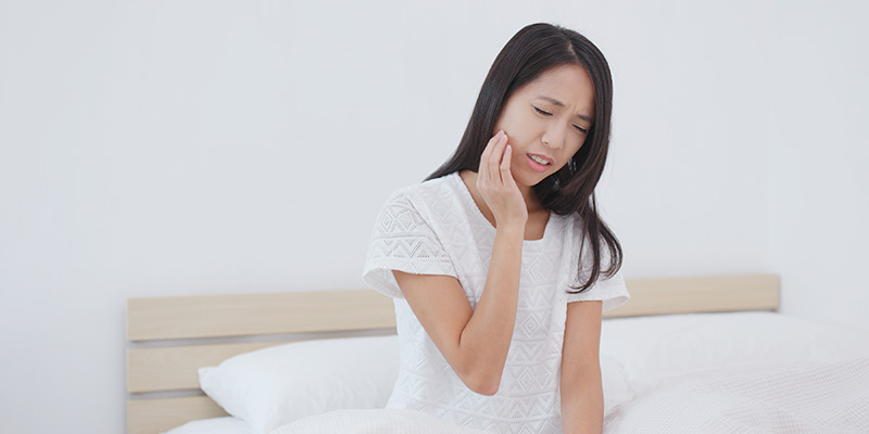 痛みに顔を歪ませ、頬をおさえる女性