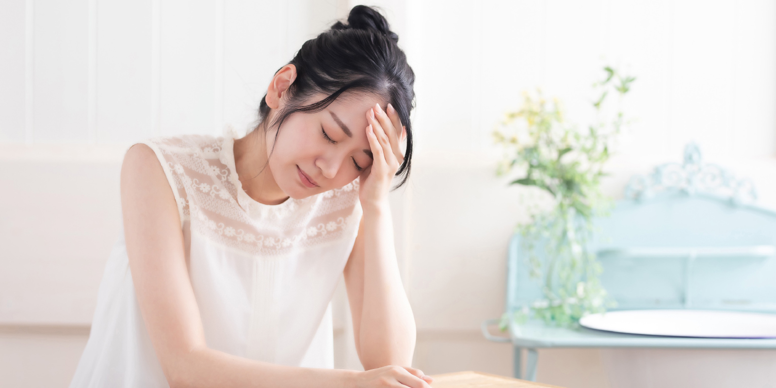 歯科治療に恐怖心があり頭を抱える女性