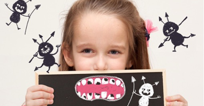 小さな女の子が虫歯で汚れた歯がたくさんあるイラストを口に重ねていて、周りにはばい菌が笑って飛んでいるイメージ