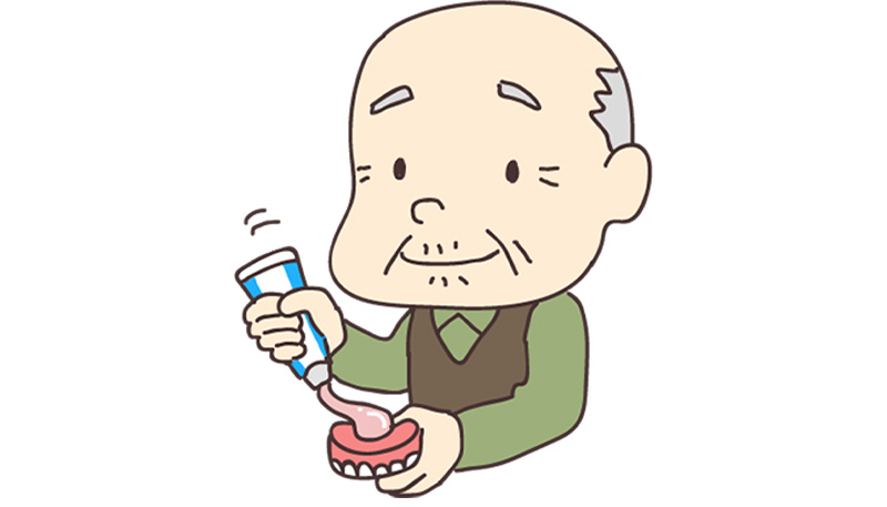 入れ歯に入れ歯安定剤を出しているお年寄りのイラスト