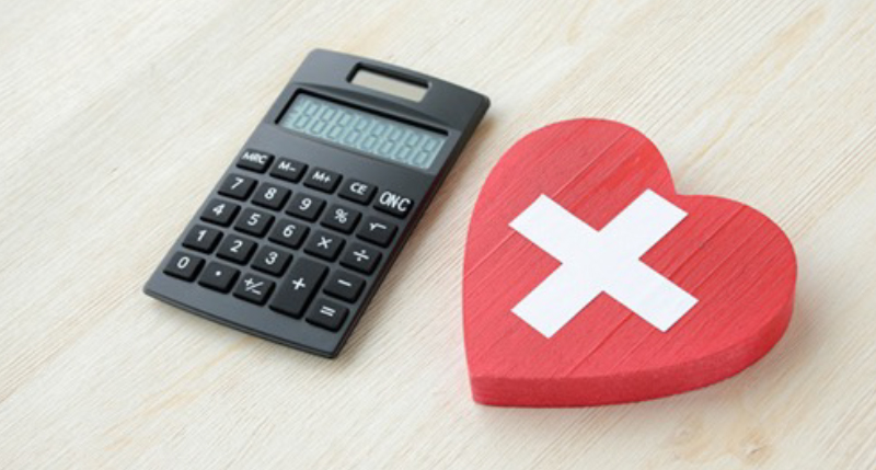 電卓と赤いハートに十字マークの書かれた物の写真