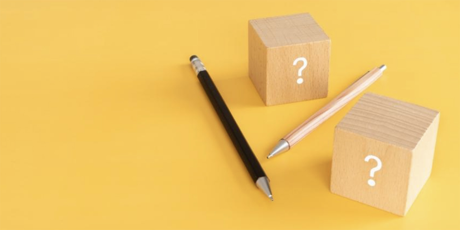 ？の書かれた正方形のブロックと転がるペン