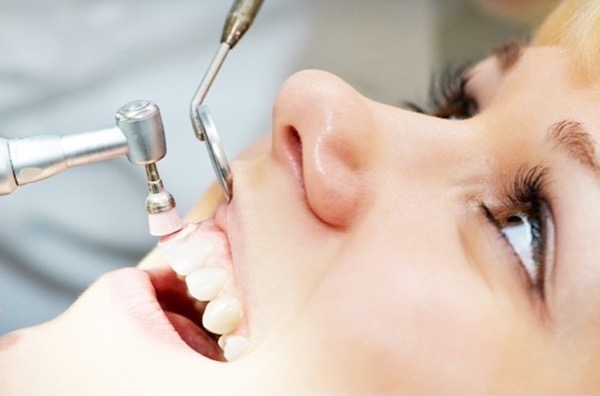 歯科医院の歯のクリーニング専用の機械で歯を磨かれている様子