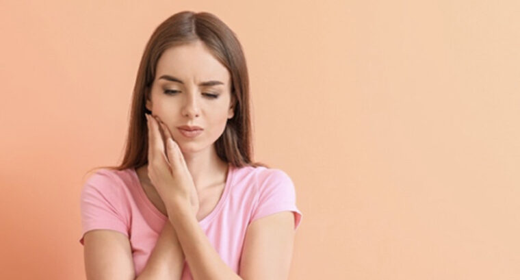 痛みに顔を歪ませ、頬をおさえる女性