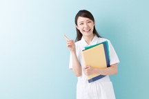 資料を片手に、指を一本立て笑顔の女性