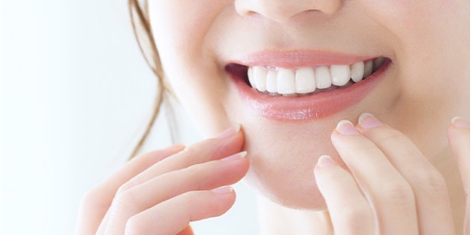 口元に手を当て綺麗な歯を見せながら微笑む女性