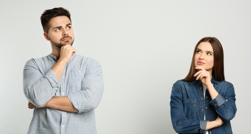 顎に手を置き考える男女の写真