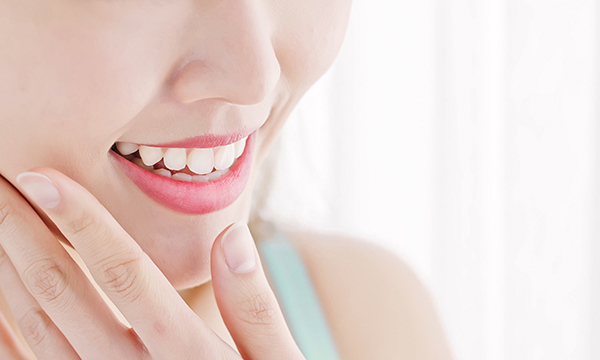 顎を押さえ微笑む女性