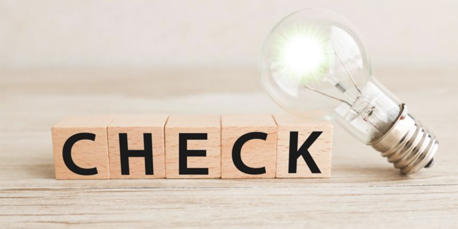 CHECKと書かれた木のブロックと電球の写真