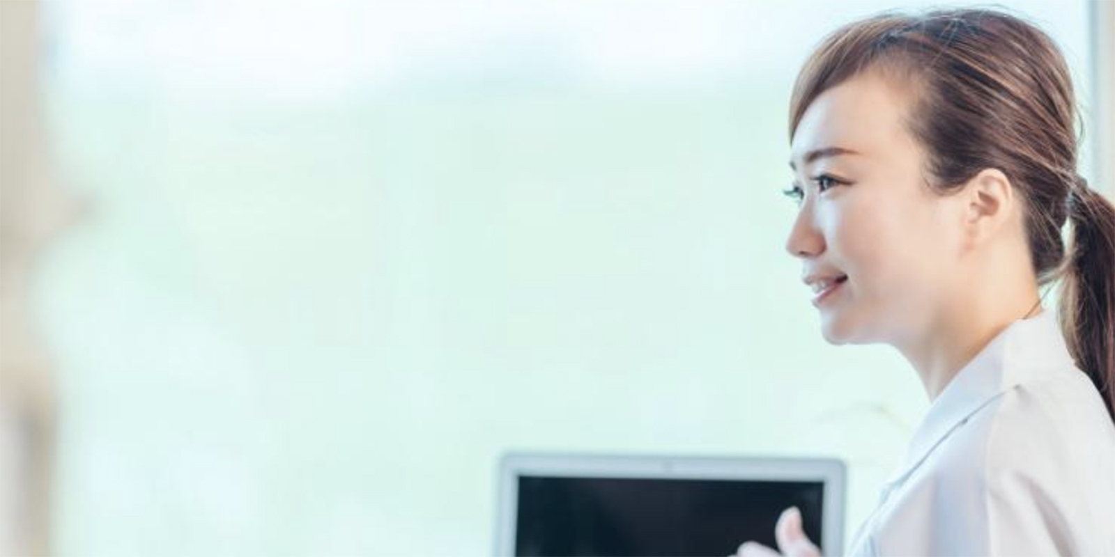 モニターを使用し説明をする女性スタッフ